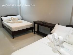 碧瑶拉法米尔旅馆的配有两张床铺、一张桌子和毛巾的客房