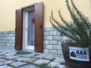 基亚文纳B&B Valle Spluga Il Pertugio的房屋前有标志的门