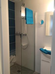 瓦尔内明德Apartment Warnemünde 15的带淋浴和蓝色毛巾的浴室