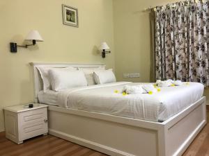 科钦水仙苑香料酒店的卧室配有白色的黄色鲜花床