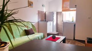 蒂瓦特Apartments Mila Tivat的客厅配有绿色沙发和桌子
