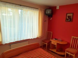 KadarėsPiligrimo Užeiga的一间卧室配有一张床、一张桌子和一台电视