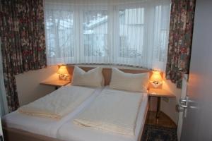 拉茨查赫·奥伯登弗沃尔绰斯酒店的一张位于房间的床,桌子上放着两盏灯