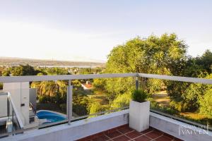 维拉卡洛斯帕兹Posada del Vaivén的阳台享有游泳池和树木的景致。