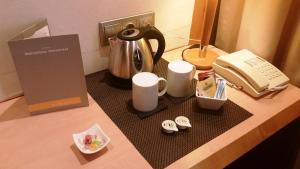 巴塞罗那巴塞罗那环球酒店的一个带咖啡壶的柜台和电话