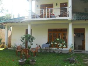 波隆纳鲁沃日落旅游之家民宿的房屋设有带桌椅的阳台