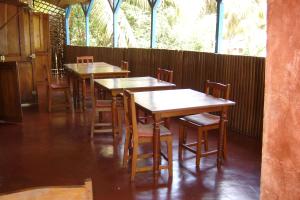 阿姆巴托洛阿卡Hotel La Caravelle的餐馆里一排木桌和椅子