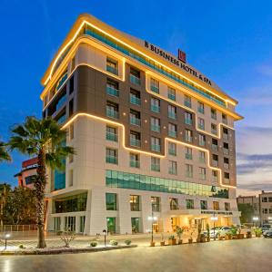 安塔利亚B商务酒店及Spa的一座酒店大楼,前面有棕榈树