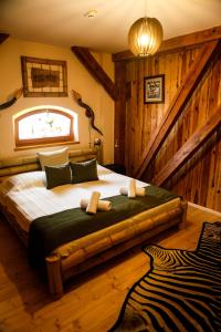 瓦沙罗什瑙梅尼Hunor Hotel és Étterem的一间带一张大床的卧室,位于带木墙的房间