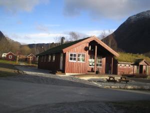 勒尔达尔Seim Camping - Røldal的一座小木结构建筑,前面设有长凳