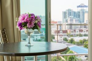 曼谷沙吞佳地宾馆的花瓶坐在窗前的桌子上