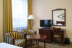 维尔扬迪维尔扬迪大酒店的酒店客房设有电视、两把椅子和一张桌子