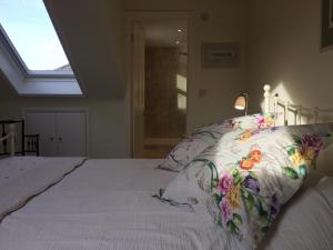 泰丁敦伦敦西南老站花园住宿加早餐旅馆的一间卧室配有一张带花卉枕头的大床