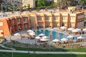 开罗Jewel Glorious Hotel的酒店设有一个游泳池、桌子和遮阳伞
