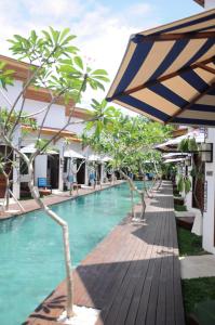 吉利特拉旺安吉利特拉旺甘贾利度假村 的一座带遮阳伞的游泳池位于度假酒店旁