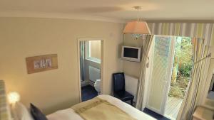 圣艾夫斯拉磨纳旅馆的一间卧室设有一张床、一个窗口和一台电视