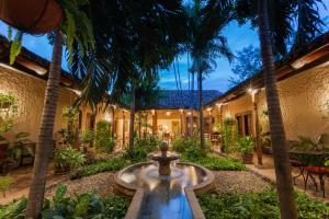 马那瓜Hotel Los Robles, Managua, Nicaragua的庭院设有喷泉和棕榈树