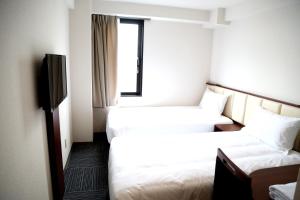 成田成田爱森酒店的酒店客房设有两张床和电视。