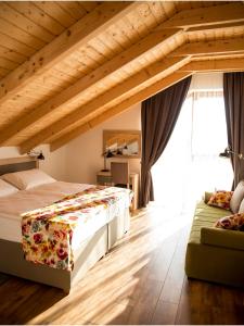 别洛瓦尔Bed&Breakfast Vinarija Coner的一间卧室配有一张大床和一张沙发