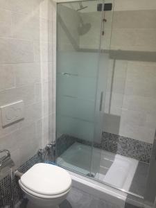 米兰MRHostel Milano的一间带卫生间和玻璃淋浴间的浴室