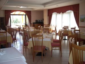 圣乔瓦尼·罗通多玛格丽特酒店的一间带桌椅的用餐室和一间带白色桌子的房间