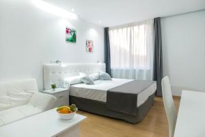马德里Boutique Urban Madrid Génova的白色卧室配有床和白色沙发
