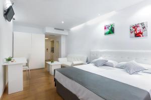 马德里Boutique Urban Madrid Génova的一间白色的卧室,配有床和客厅