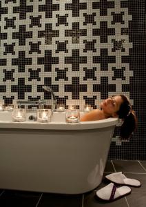 贝尔法斯特首选贝尔法斯特费兹威廉酒店的妇女在浴室的浴缸里躺着