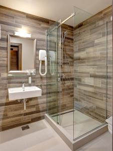 贝尔格莱德扎威萨卡弗利酒店的一间带玻璃淋浴和水槽的浴室