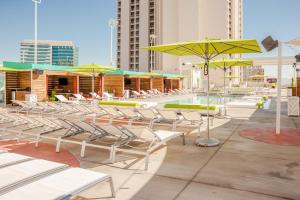 拉斯维加斯Plaza Hotel & Casino的庭院里设有一组椅子和遮阳伞,还有一个游泳池