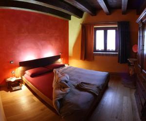 ColledaraB&B Scacciapensieri - Vini d'Altura的一间卧室设有一张红色墙壁的大床