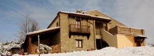 ColledaraB&B Scacciapensieri - Vini d'Altura的积雪中带阳台的砖屋