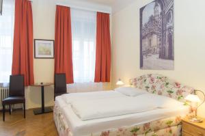 维也纳雷勒豪斯公寓的一间卧室配有床和红色窗帘的窗户