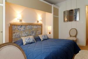 卡尔卡松Domaine d'Auriac - Relais & Châteaux的一间卧室配有蓝色的床和两个枕头