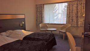 尼克宾法尔斯特法尔斯特岛酒店的酒店客房带一张床、一张桌子和椅子