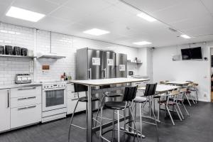 斯德哥尔摩城市旅舍的厨房配有吧台凳和不锈钢用具