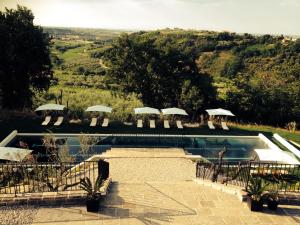 VillalfonsinaVillalfonsina Country House的一个带遮阳伞和椅子的景观游泳池