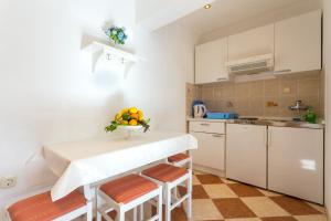 波梅纳Apartments Slavica的厨房配有桌子和一些水果