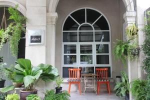 曼谷紫菀9号住宿加早餐旅馆的种植了植物的门廊上摆放着两把椅子和一张桌子