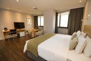 瓜亚基尔统一公园欧罗韦德酒店的酒店客房设有一张大床和一张书桌。