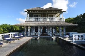 OrtonsBelle Mont Sanctuary Resort - Kittitian Hill的大楼前带游泳池的房子