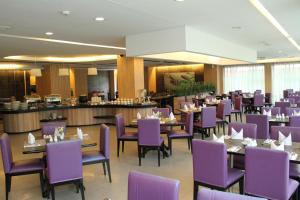 北干巴鲁安卡萨花园酒店的一间用餐室,配有紫色的椅子和桌子