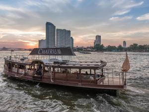 曼谷察殿曼谷河畔酒店的水中的小船,上面有标志
