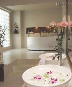 顺化顺化亚洲大酒店的浴室配有水槽和鲜花浴缸