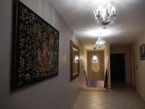 CorbenyLogis Hotel du Chemin des Dames的墙上挂有画作的走廊和吊灯