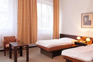 尼萨河畔亚布洛内茨莫库尔酒店 - 尼斯河畔亚布洛内茨的酒店客房,配有两张床、一张桌子和一把椅子