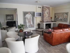 里奥阿波罗酒店的客厅配有真皮沙发和白色椅子