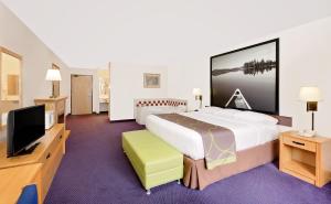Saint James圣詹姆斯速8酒店的一间酒店客房,配有一张大床和一台平面电视
