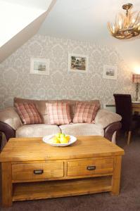卡布里奇Strathspey Cottage的客厅配有沙发和桌上一碗水果