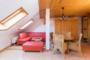 耶拿Apartments Ilmtal-Jena的客厅配有红色的沙发和桌子